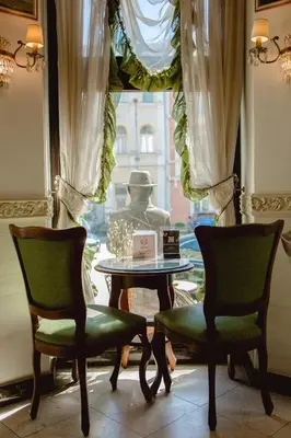 a table and chairs in front of a window at Royal Hotel in Varna City
