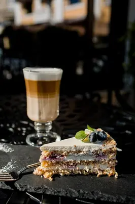 a piece of cake and a drink on a table at Royal Hotel in Varna City