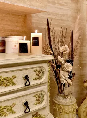 a white dresser with a candle and flowers on it at Royal Hotel in Varna City