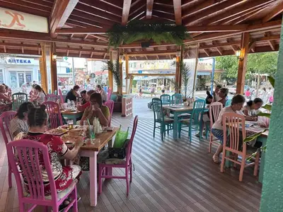 a group of people sitting at tables in a restaurant at Къща за гости КАТИ in Kiten