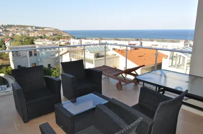 a balcony with chairs and a table and the ocean at Beautiful family villa with sea view in Byala