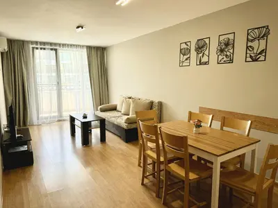 a living room with a table and a couch at Teos Apartments Primorsko in Primorsko