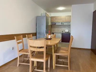 a kitchen and dining room with a table and chairs at Teos Apartments Primorsko in Primorsko