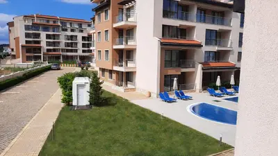an apartment building with chairs and a swimming pool at Obzor Beach Resort Apartment G-109 in Obzor
