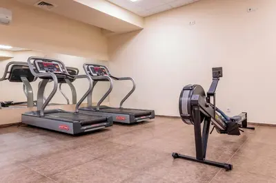 a gym with three cardio machines in a room at Obzor Beach Resort Apartment G-109 in Obzor