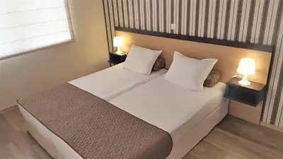 a bedroom with a large bed with two lamps at Obzor Beach Resort Apartment G-109 in Obzor