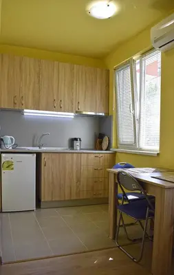 a kitchen with wooden cabinets and a white refrigerator at Starlight Studios in Burgas City