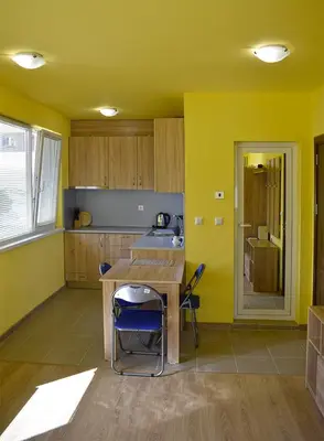 a kitchen with yellow walls and a table and chairs at Starlight Studios in Burgas City