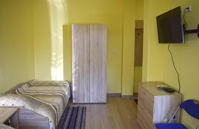 a bedroom with a bed and a cabinet and a television at Starlight Studios in Burgas City