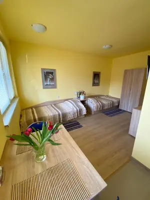 a living room with couches and a table with flowers at Starlight Studios in Burgas City
