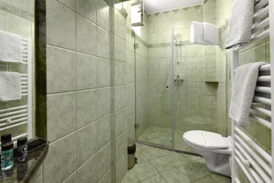 a bathroom with a toilet and a glass shower at Boryana Hotel in Burgas City