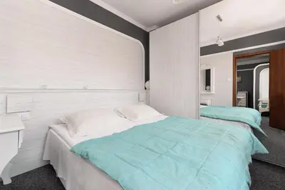 a bedroom with two beds and a desk at Boryana Hotel in Burgas City