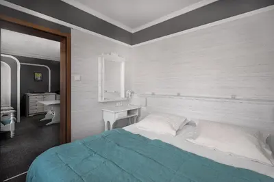 a bedroom with a bed and a desk and a window at Boryana Hotel in Burgas City