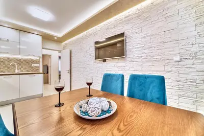 a table with two wine glasses and a plate of food at Апартамент S Apart in Varna City