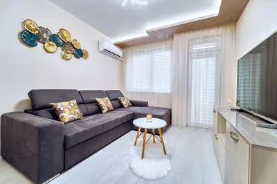 a living room with a couch and a table at Апартамент S Apart in Varna City