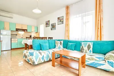 a living room with a blue couch and a table at BulgariaVilla - Green Life Villas in Bryastovets
