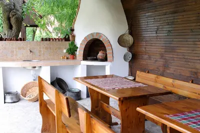 a dining room with a table and a pizza oven at BulgariaVilla - Green Life Villas in Bryastovets