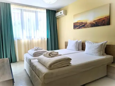 a bedroom with two beds with towels on them at Apartments Stamopolu Lux with pool view in Primorsko