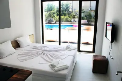 a bedroom with a white bed with a large window at Apartments Stamopolu Lux with pool view in Primorsko