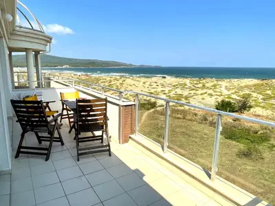 a balcony with a table and chairs and the ocean at Sea View Apartment free parking in Primorsko