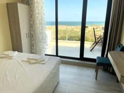 a bedroom with a bed and a view of the ocean at Sea View Apartment free parking in Primorsko