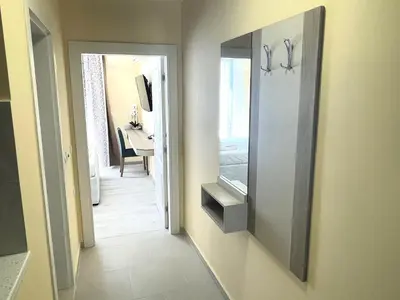 a hallway with a mirror and a door to a room at Sea View Apartment free parking in Primorsko