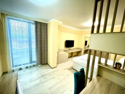 a room with a bedroom with a bed and a television at Sea View Apartment free parking in Primorsko