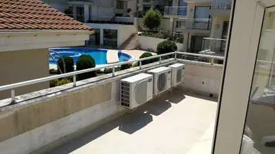 an apartment balcony with two air conditioners and a swimming pool at Cozy family villa 500m. from the beach in Byala
