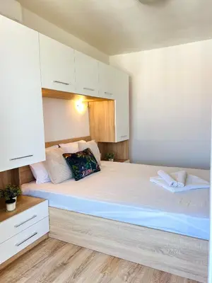 a bedroom with a large bed with white cabinets at Summer Apart Janet in Obzor