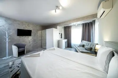 a hotel room with a large bed and a couch at Boutique Guest House