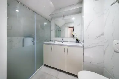 a white bathroom with a sink and a shower at Boutique Guest House