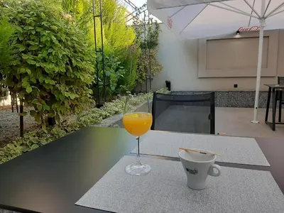 a glass of orange juice and a cup on a table at Boutique Guest House