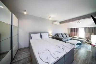 a bedroom with a large bed and a couch at Boutique Guest House