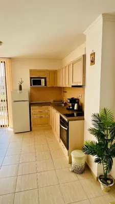 a kitchen with wooden cabinets and a white refrigerator at Villa CALABRIA in Sveti Vlas