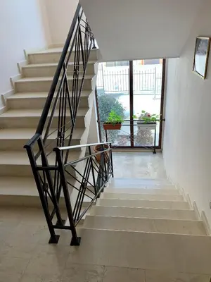 a staircase in a house with a black metal railing at Villa CALABRIA in Sveti Vlas