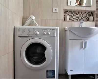 a washing machine in a bathroom next to a sink at Studio Emi in Pomorie