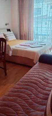 two twin beds in a room with a window at ЛЕСО-Зара студио in Ravda