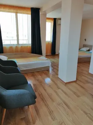a room with two beds and a couch and a chair at Дом Апостолови in Sozopol