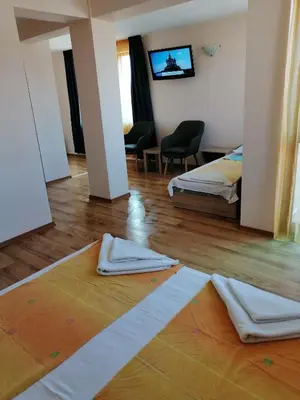 a hotel room with two beds and a television at Дом Апостолови in Sozopol