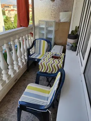 a pair of chairs and a table on a balcony at Самостоятелни стаи Виктория in Pomorie