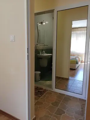 a bathroom with a mirror and a sink at Самостоятелни стаи Виктория in Pomorie