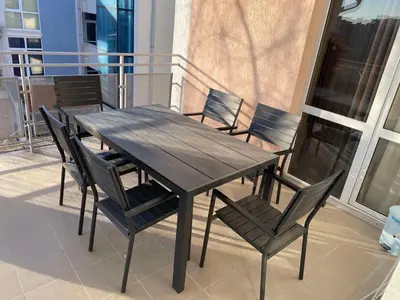 a wooden table and chairs on a balcony at ELIT 2 APART HOTEL in Sunny Beach