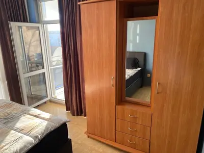 a bedroom with a wooden cabinet with a mirror at ELIT 2 APART HOTEL in Sunny Beach