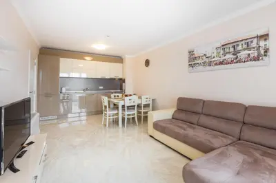 a living room with a couch and a kitchen at FLORENCE SUITES APART HOTEL in Sveti Vlas