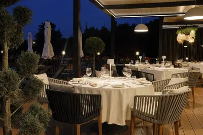 a group of tables with wine glasses and chairs at Viva Mare Beach Hotel by Santa Marina in Sozopol