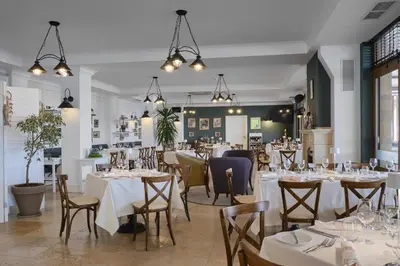 a dining room with white tables and chairs at Viva Mare Beach Hotel by Santa Marina in Sozopol