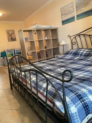 a bedroom with a bed with a blue comforter at Tiny Bijou Sea View studio - Santa Marina - Sozopol in Sozopol