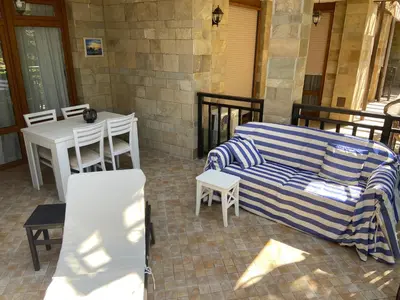 a patio with a couch and a table and chairs at Tiny Bijou Sea View studio - Santa Marina - Sozopol in Sozopol