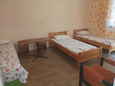 a small room with two beds and a table at Бунгала Дъбрава in Shkorpilovtsi