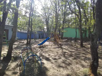 a playground in the middle of a forest with trees at Бунгала Дъбрава in Shkorpilovtsi